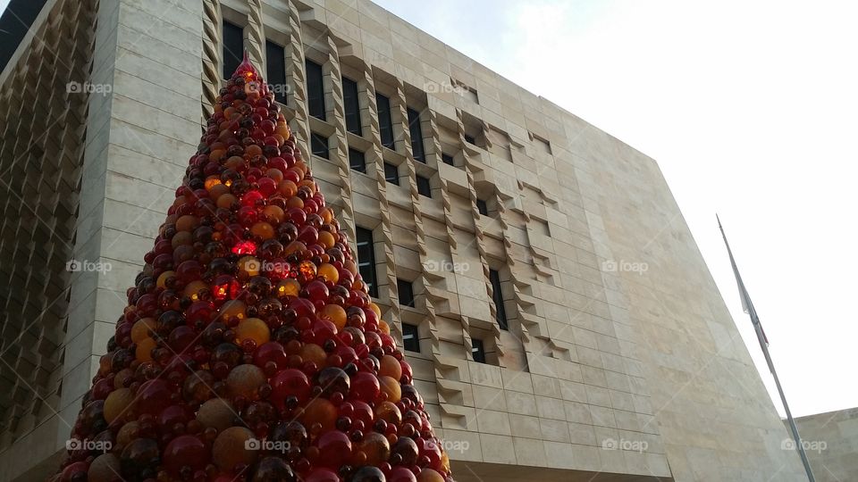 glass bauble Christmas tree in front of modern building in Malta