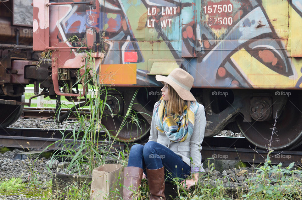 Woman sitting in front of a colorful train car