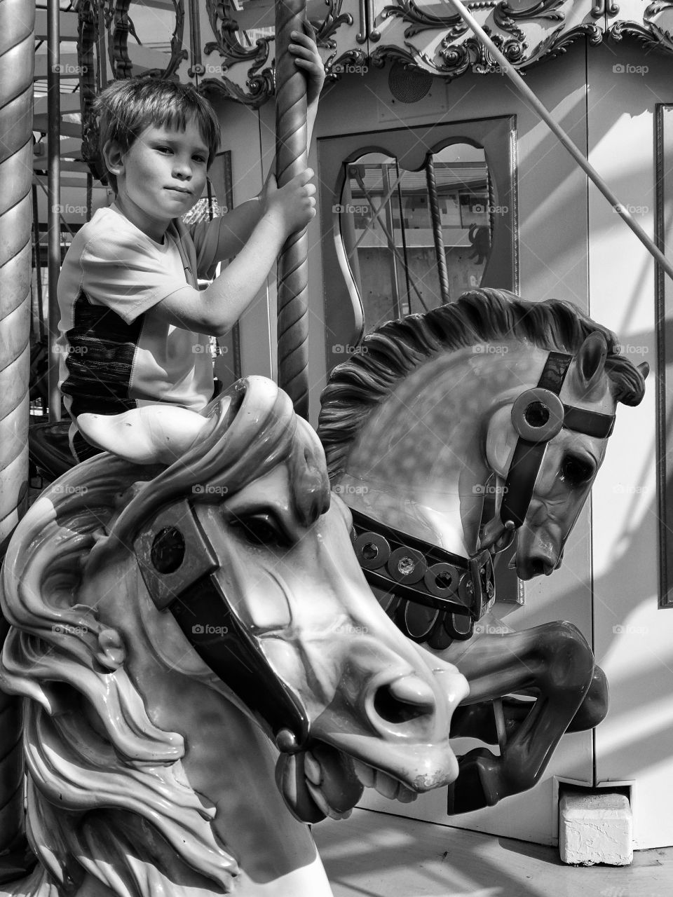 Boy Riding A Carousel. Young Boy Riding On A Restored Vintage Carousel
