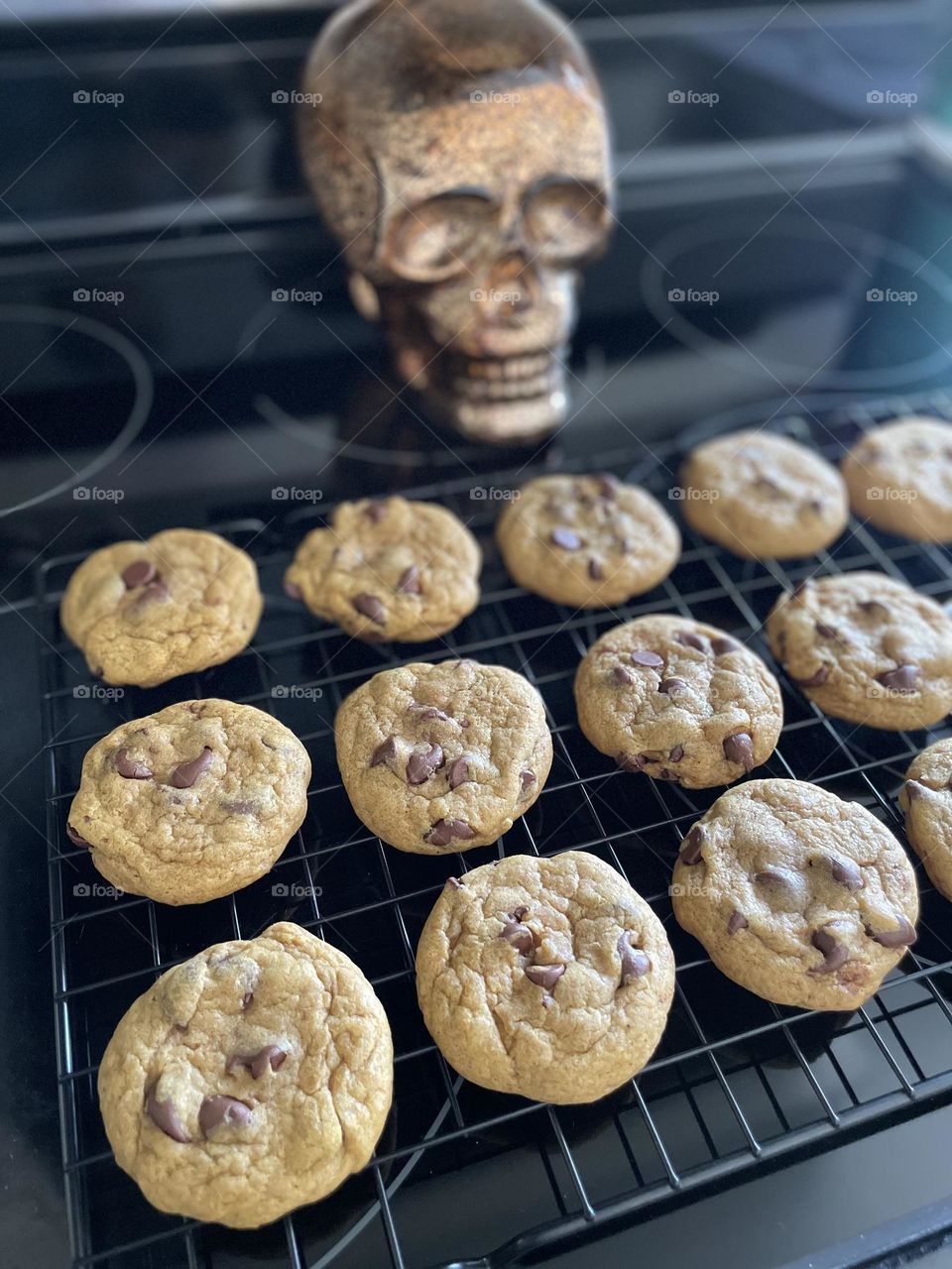 Making pumpkin chocolate chip cookies for spouse’s workplace, baking homemade treats, using in season ingredients for baking, skull in the background of cookies 