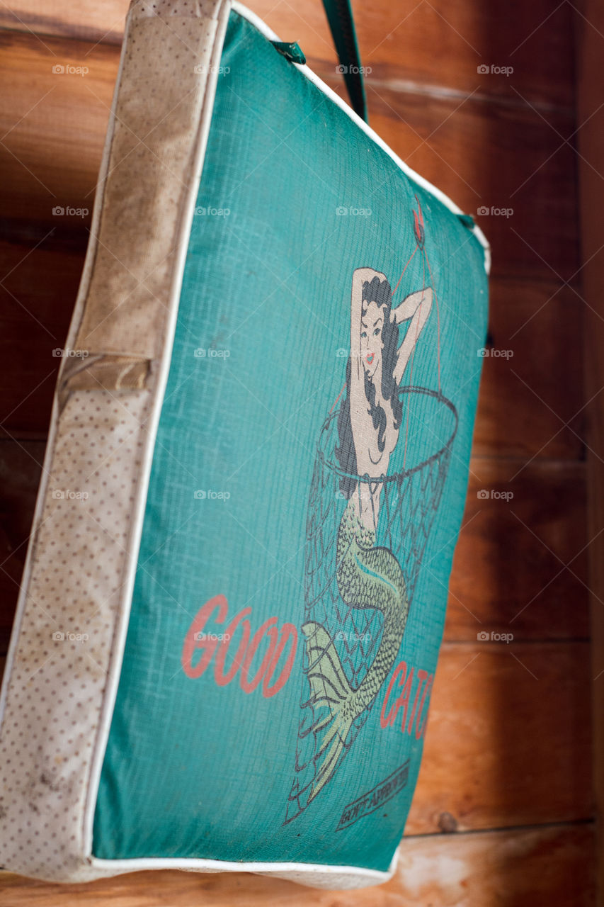 A mermaid print on a cottage boat seat reads "good catch"