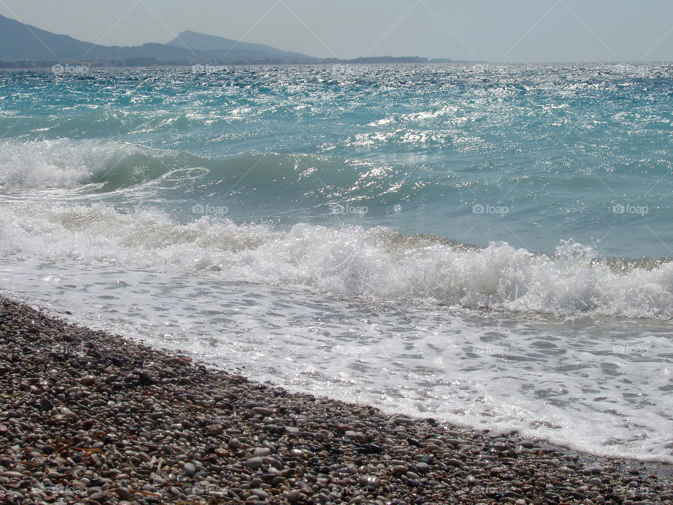 Waves on pebbles beach in Rhodes