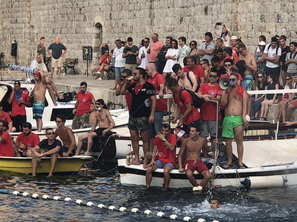 This is a picture of extremely enthusiastic fans during a water polo game in the old Harbour In Dubrovnik Croatia
