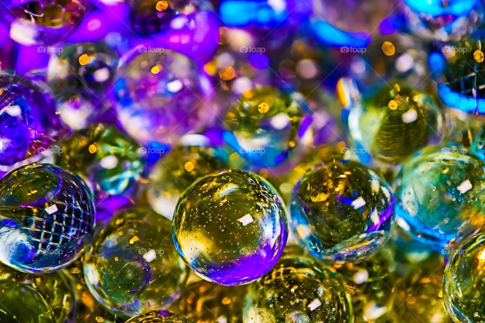 Colorful shiny glass marbles reflecting a rainbow of colors, closeup macro image 