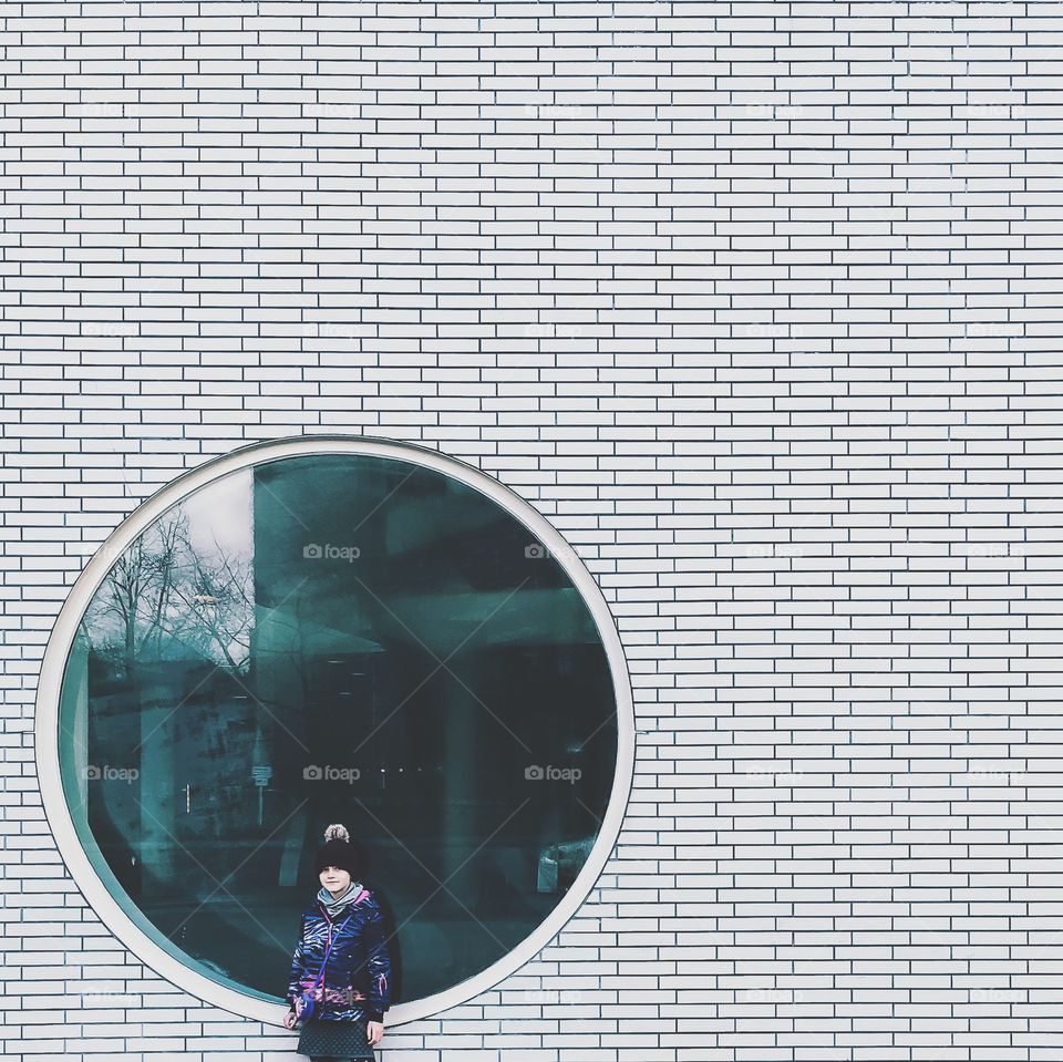 Portrait of a girl standing against white wall