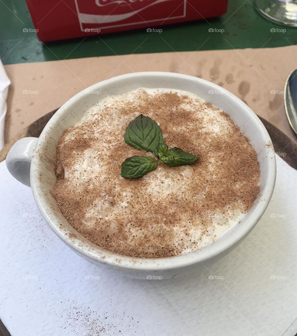 Rice with milk dusted with cinnamon powder and decorated with mint leaves, rice pudding, milk with rice, arroz con leche 