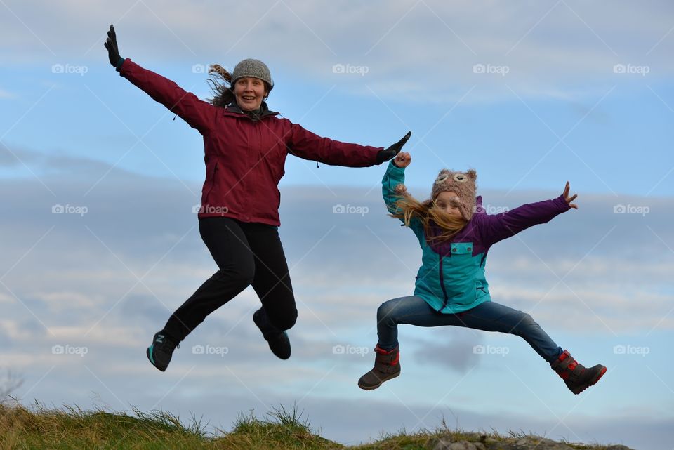 Jumping for fun. A woman and a little girl jumping for fun 