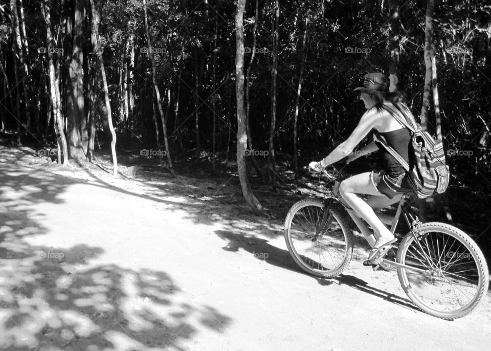 Black and White Photo of Girl Ridding a Bicycle on a Forest Path