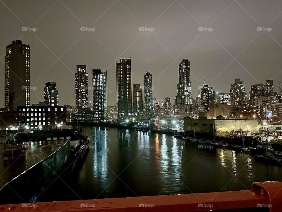 This is „Newtown Creek“ seen from the „Pulaski Bridge“ that connects „Greenpoint“, Bklyn to LIC, Queens on an evening in early December 2023. Across the water we see „Greenpoint“ to the left and LIC and „Manhattan“ on the right. Hypnotic Productions