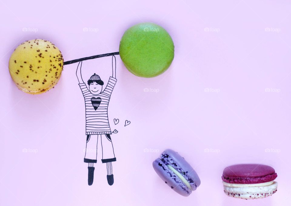 Drawing of a boy holds real circle shaped macaroons like bars