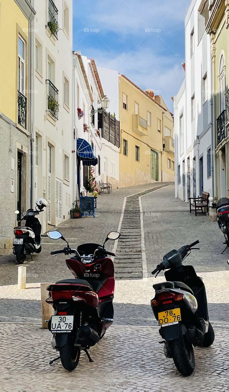 Motorbikes at the bottom of a narrow alley in Lagos Portugal 