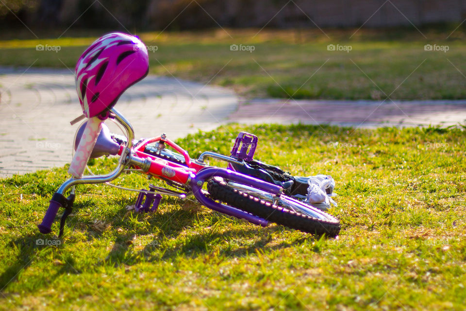 Summer memories of playing outdoors and in parks. Image of girl's pink and purple bike
