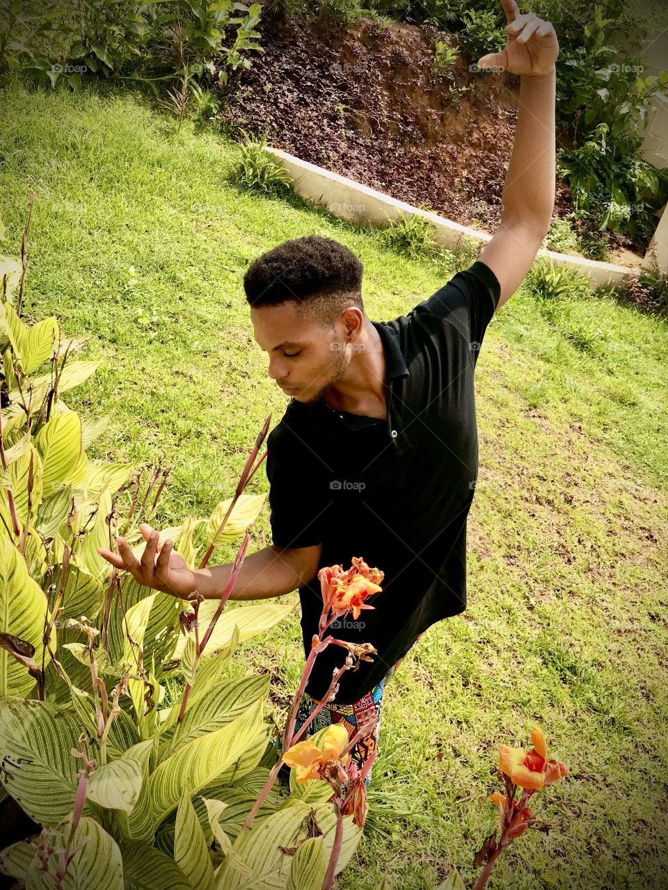 A male dancer poses with plants 