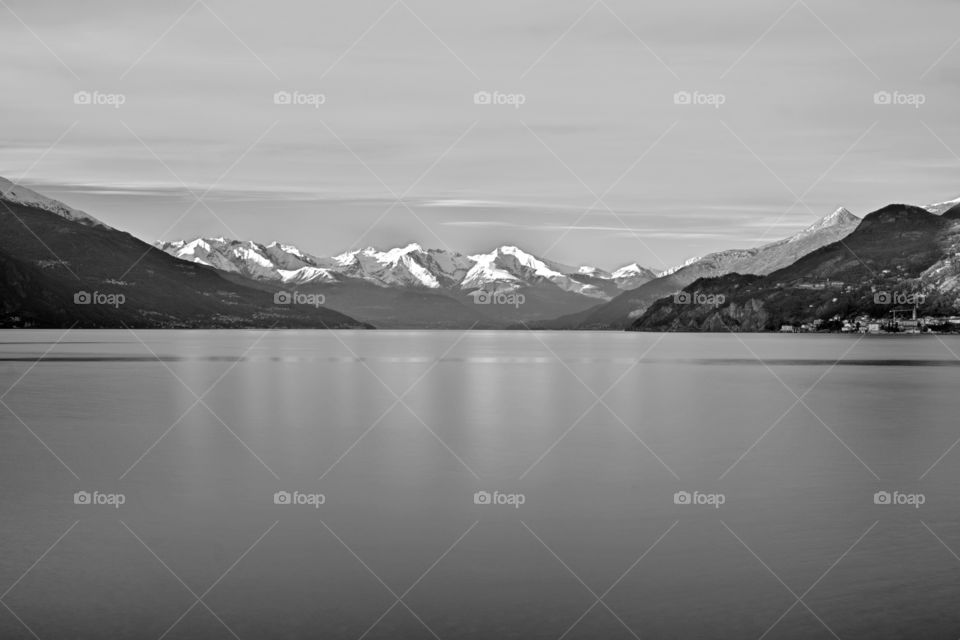 Winter Lake . Black and white photo of Lake Como by the tip of Bellagio, with snow-white Alps in the background