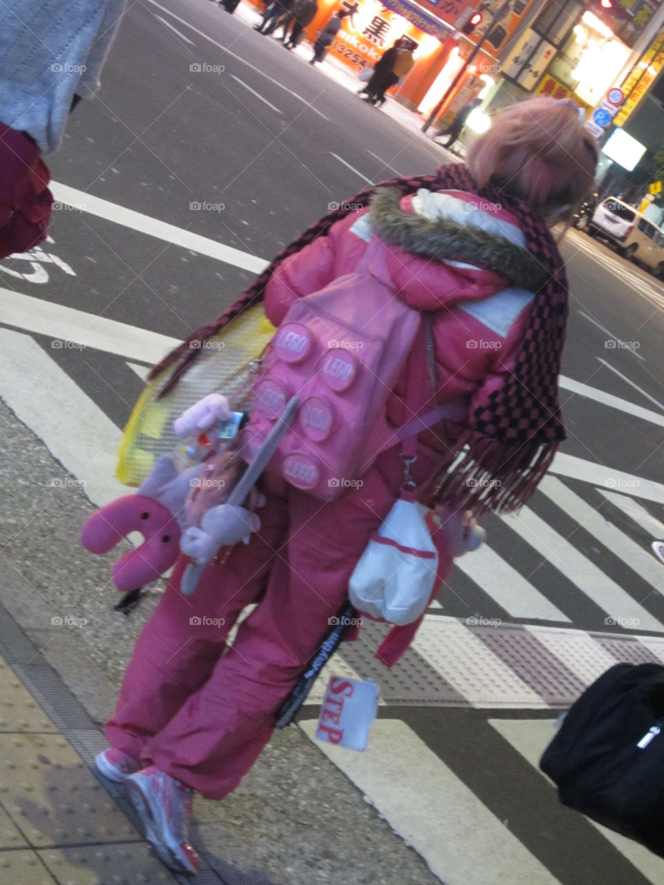 Akihabara, Tokyo, Japan. Unique Japanese street fashion.  Girl in all pink outfit, backpack with stuffed toys.