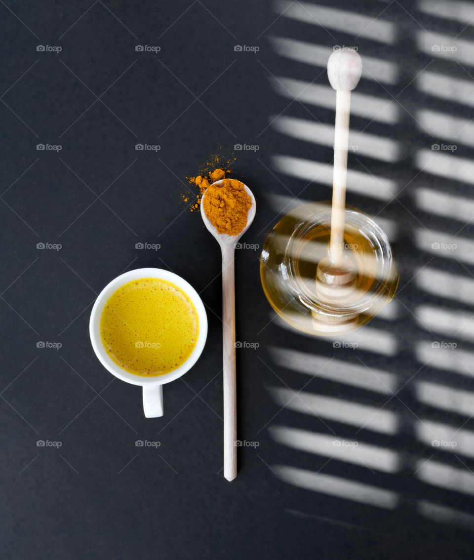 Top view to golden milk made by milk, turmeric and honey.