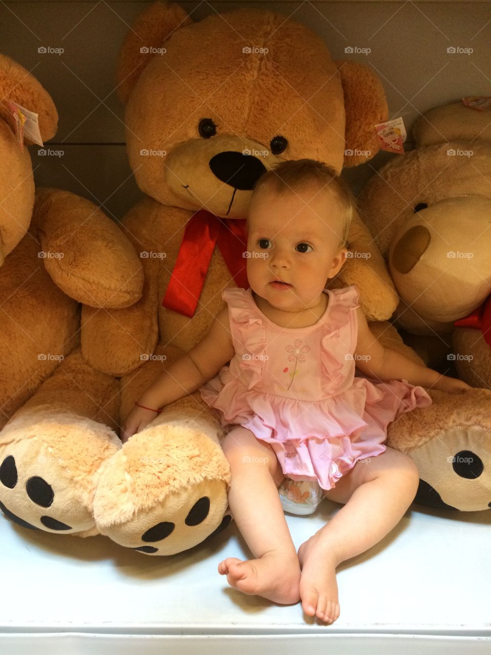 Baby girl sitting with teddy bears
