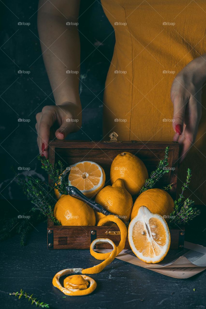 Woman holding the top of casket with fresh yellow lemons