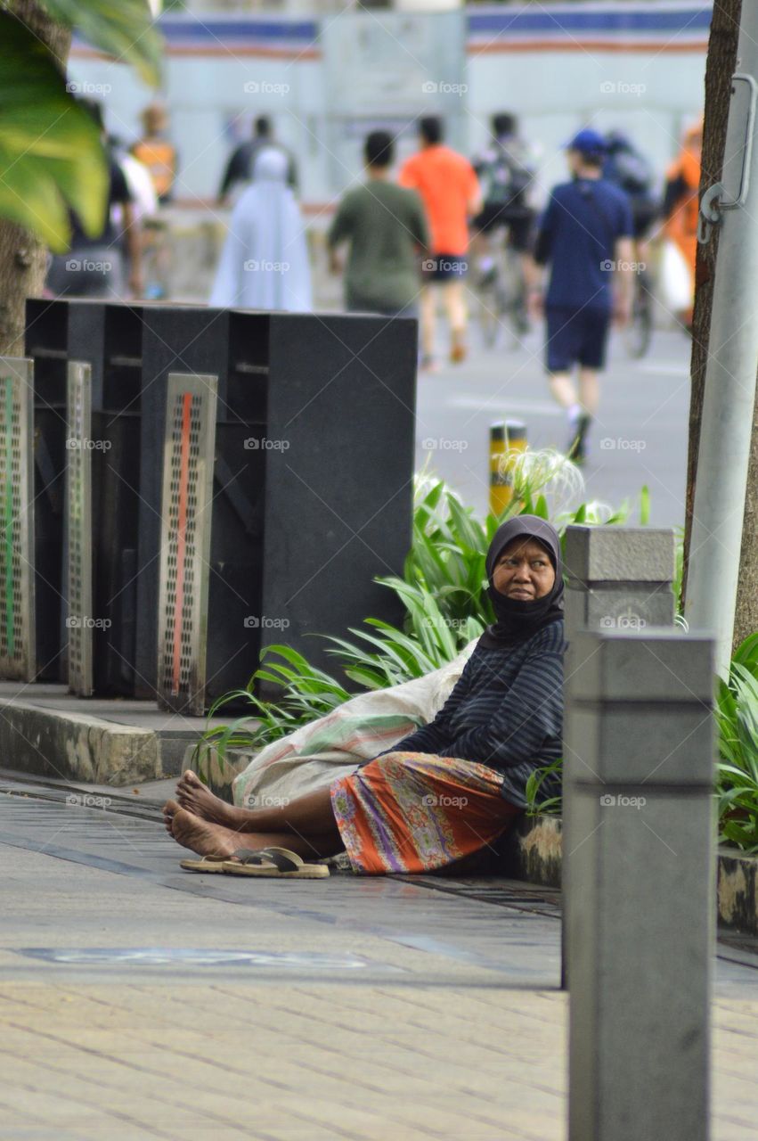 A female scavenger is resting on a sidewalk in Jakarta.  Sunday January 15, 2023