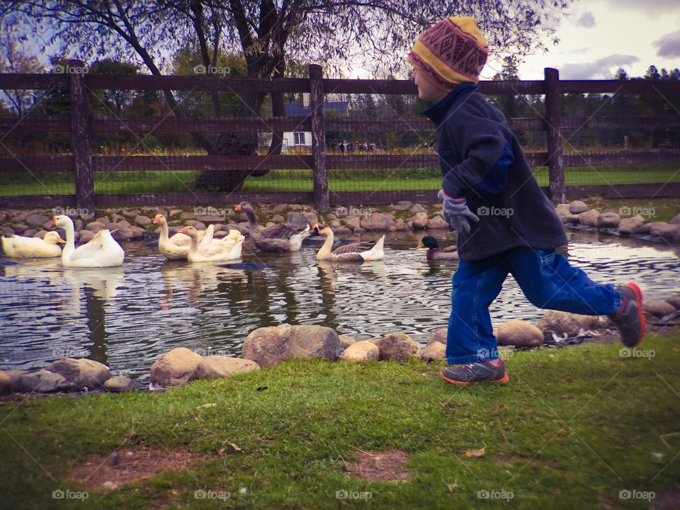 Boy running near the lake