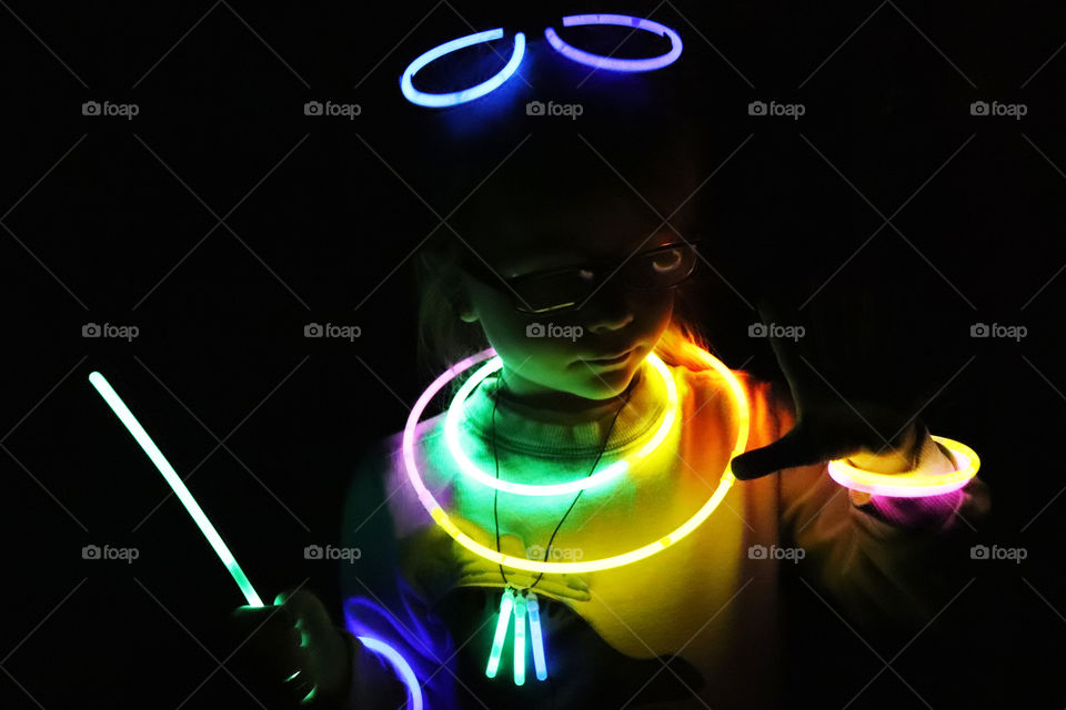 Child playing with bright colorful glowsticks