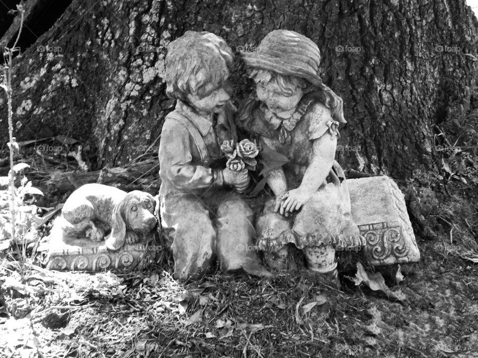 Black and white boy and girl garden statue with a puppy