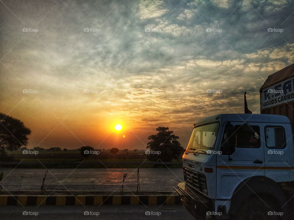 I was traveling to my home in the morning and sun was rising. I was trying to capture it in my camera and suddenly this truck came and added the beauty to the picture. 😊