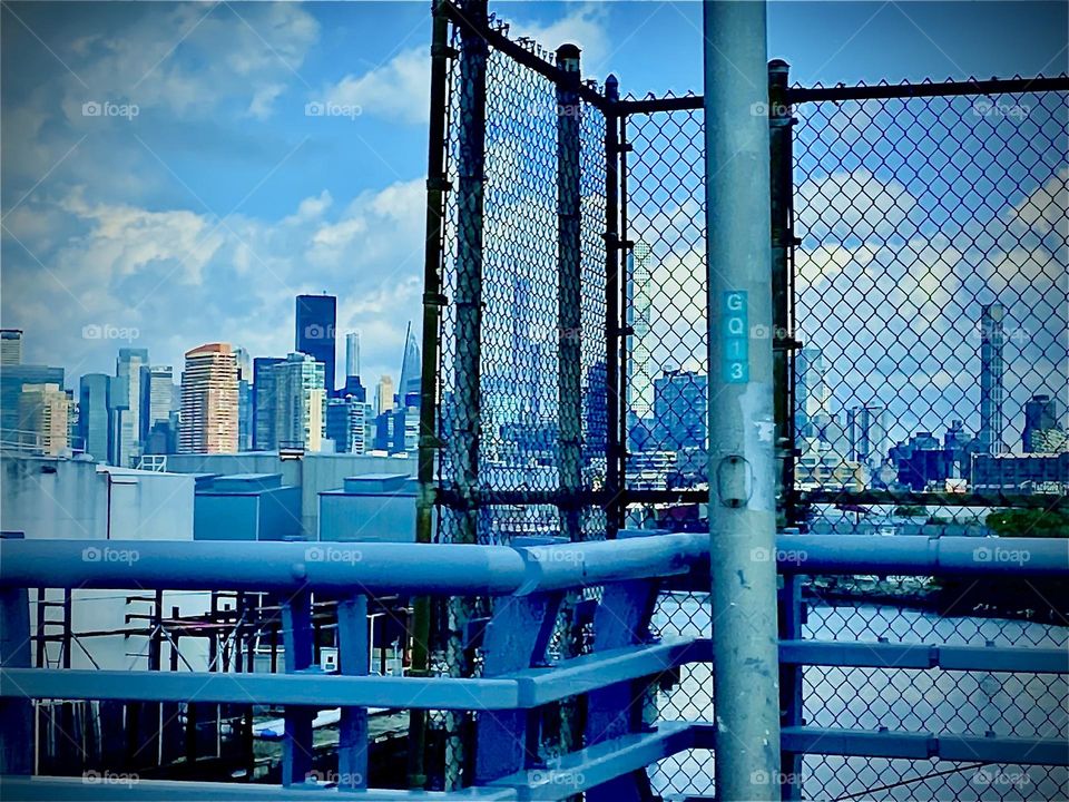 A panoramic view from the „BQE“ taken while driving into Brooklyn towards „Ft Greene“. Across the waters of the „East River“ we see the famous „Manhattan skyline“ with its multiple skyscrapers and other high rise buildings. 2022. Hypnotic Productions