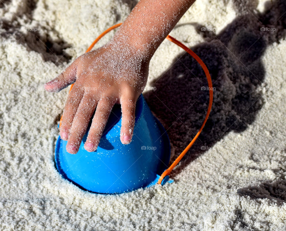 Close-up of child's hands playing in sand