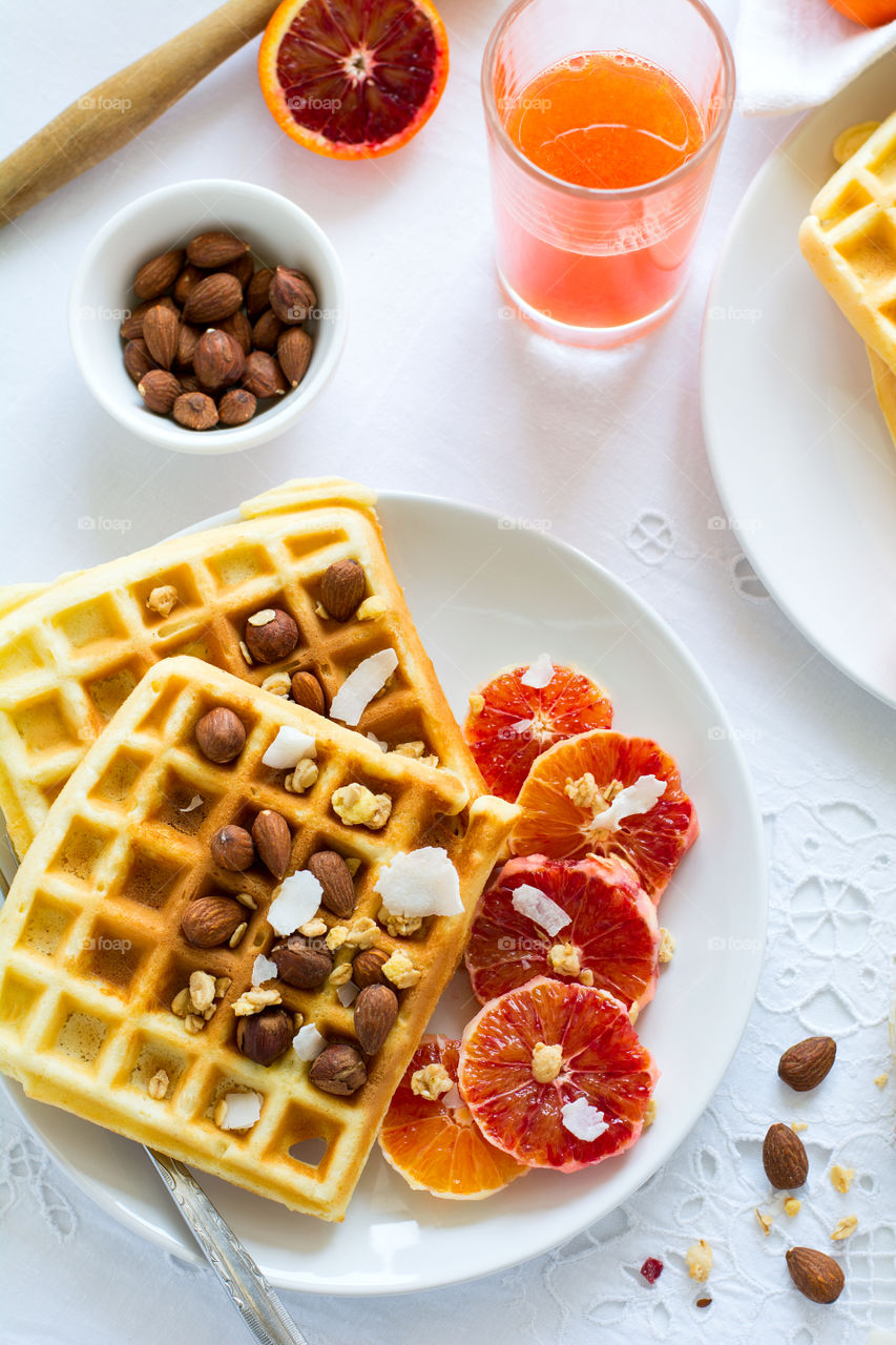 Healthy breakfast. Belgian waffles with blood orange, nuts and coconut