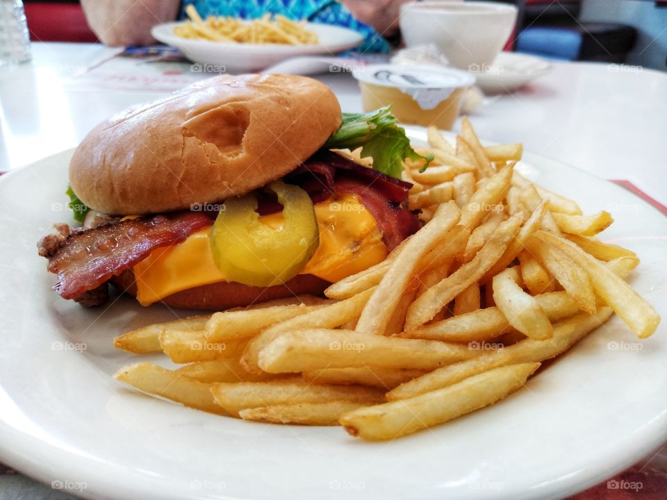 In this photo a friend an I ate lunch at Steak-N-Shake. I got a cheeseburger and french fries with a glass of water.