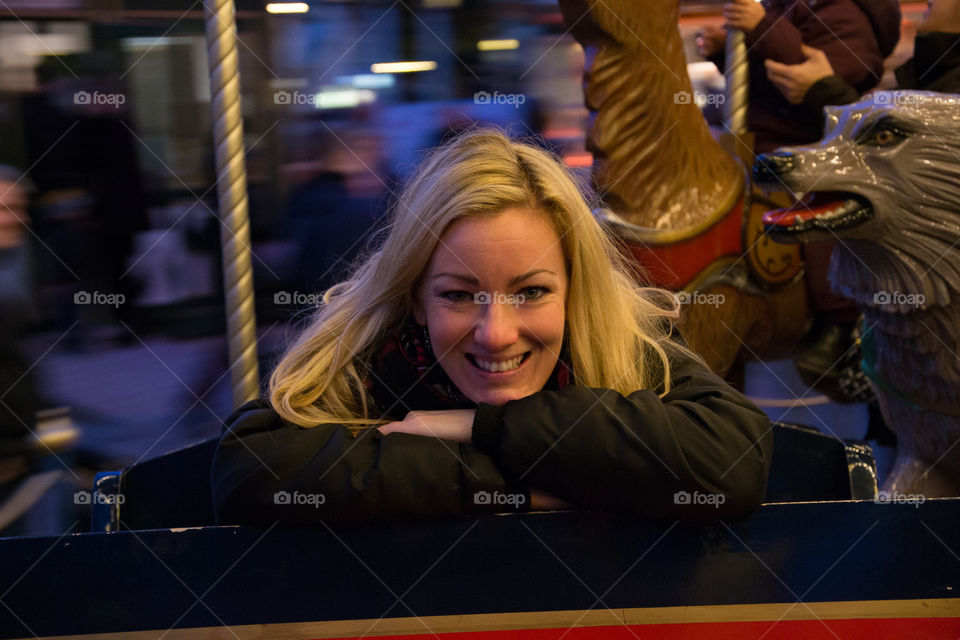 woman at the age of 30 who go carousel and smiling at theme park Tivoli in Copenhagen Denmark.