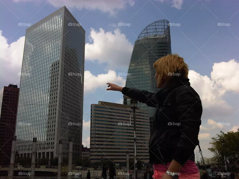 They are three giant buildings. They are in Paris near a shopping center. To be more or less at the height of the buildings, the model has climbed on top of a platform.