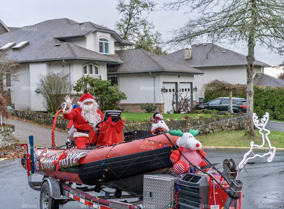 Santa arrives in the neighbourhood in his rescue boat, used by emergency workers to rescue people 