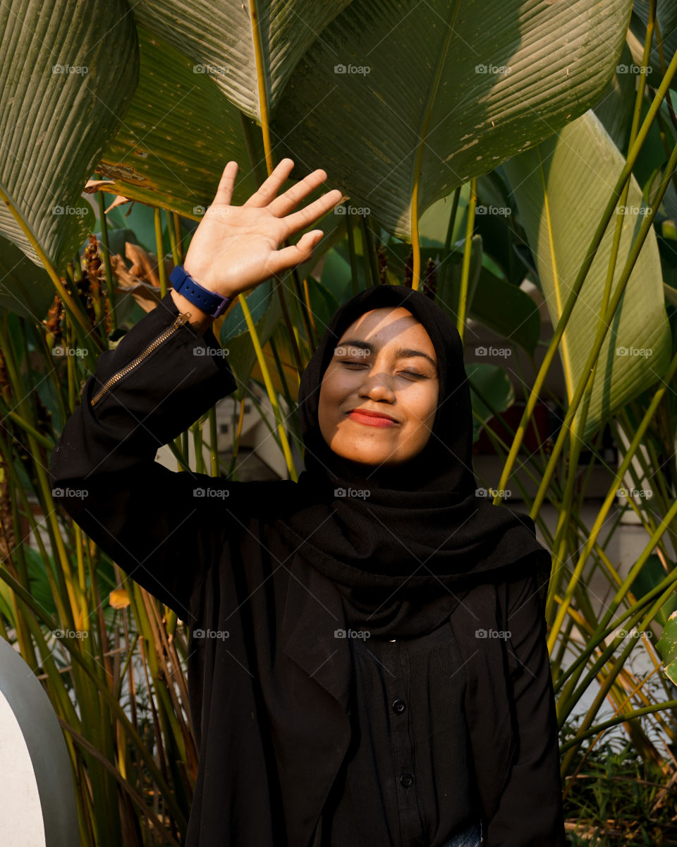 A hijaber girl is being sun kissed.