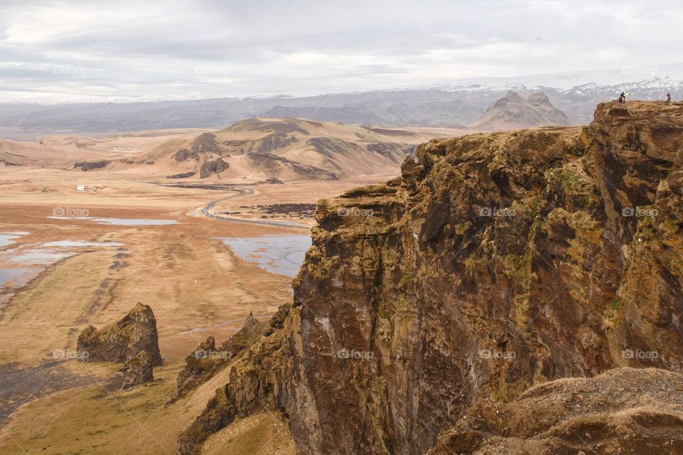 People standing on a big rock in Iceland and enjoying the view and the happiness glimmers after a long walk.