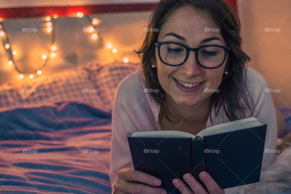 Cute girl reading in bed before sleep