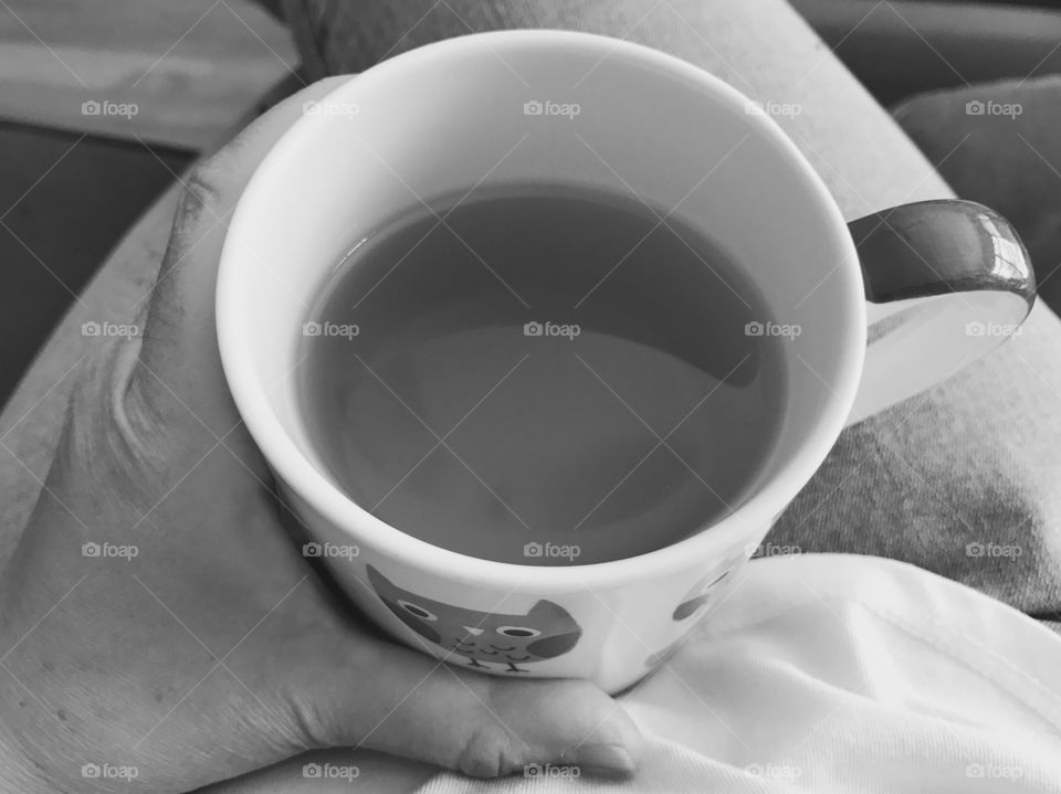 Hand holding mug of tea