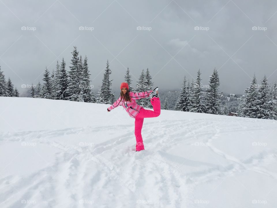 Woman in pink ski costume enjoying the snow