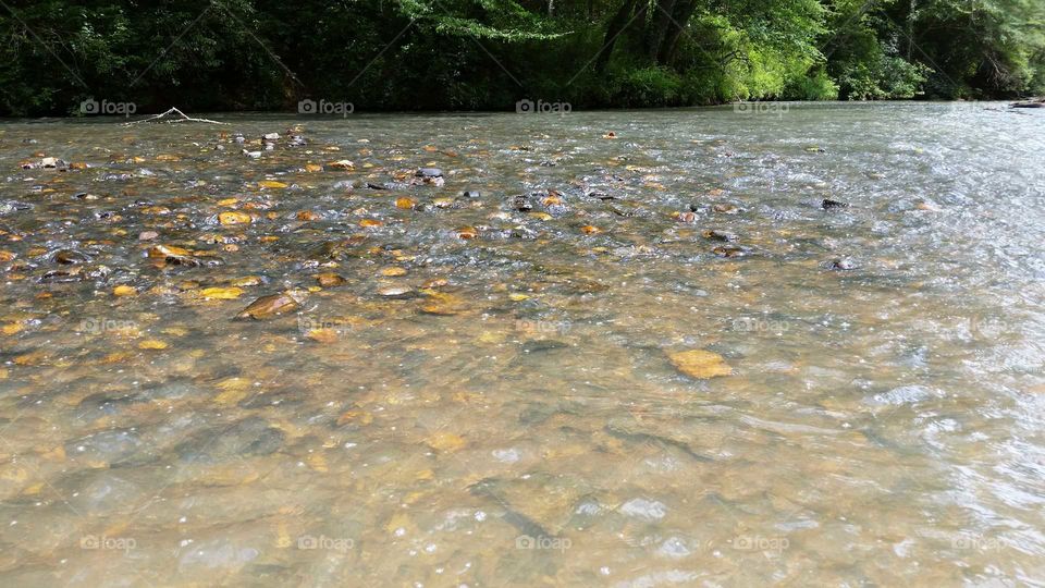 water flowing over river rocks.