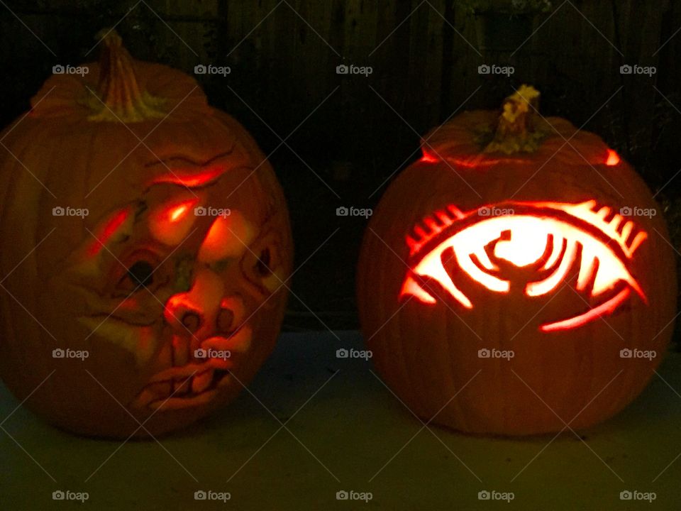 Two Halloween pumpkins lit up