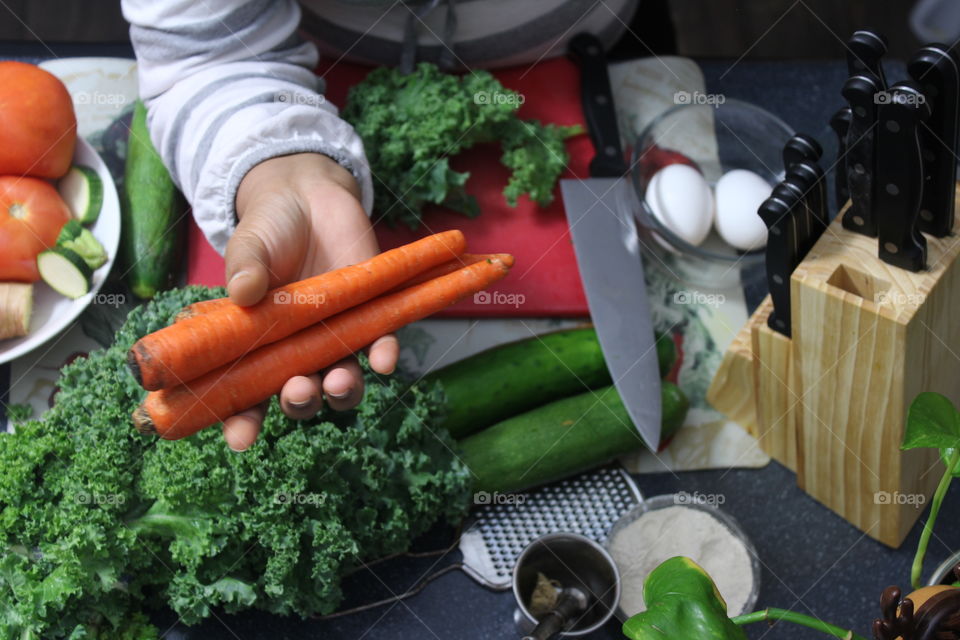 Preparing food in kitchen using vegetables and kitchen knife