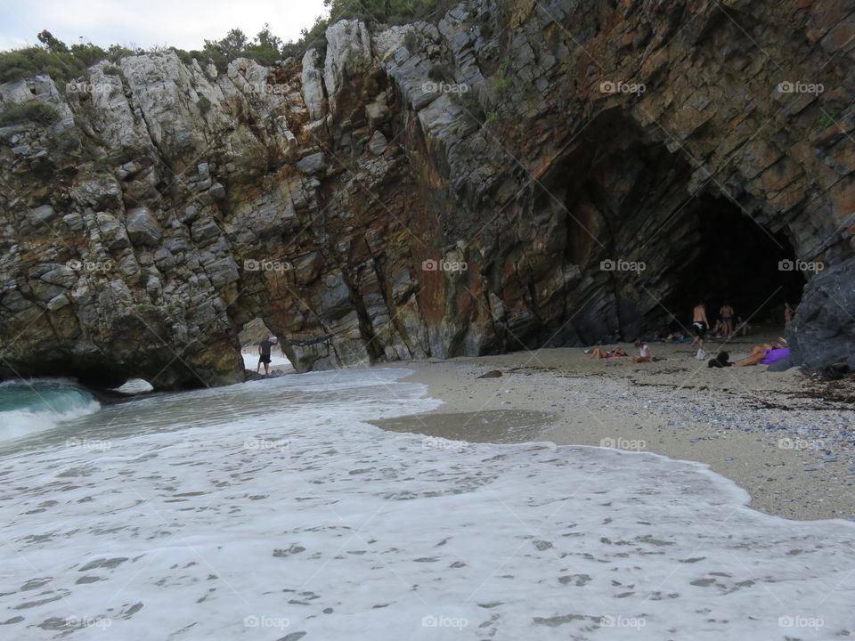 Small passage through cliff on sandy beach