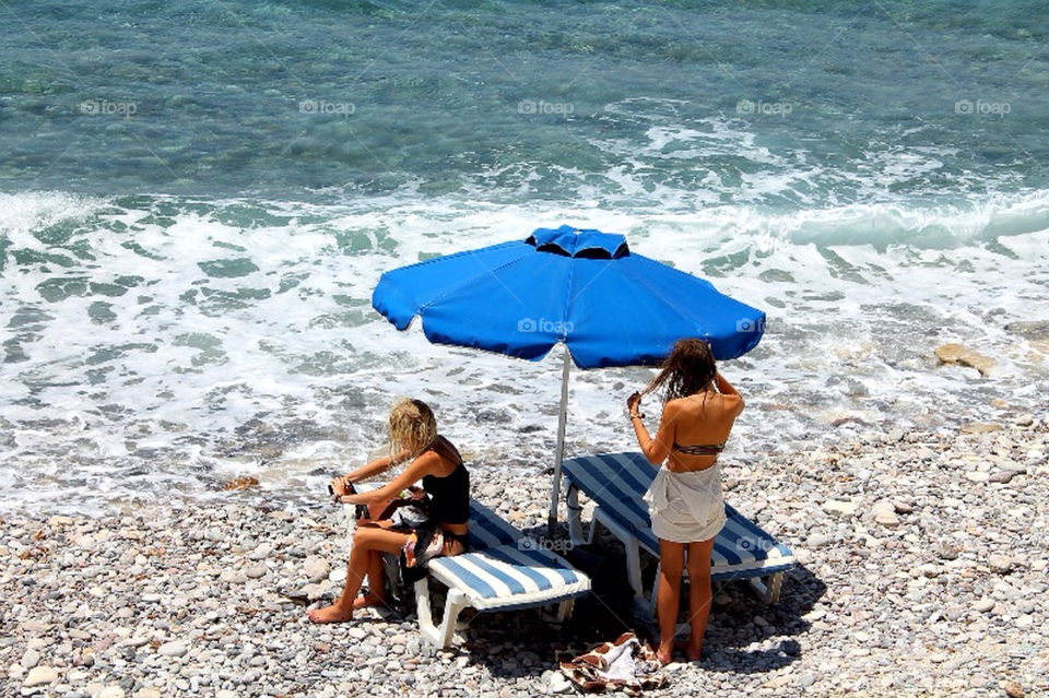 Two beautiful girls at a hideaway beach in greece