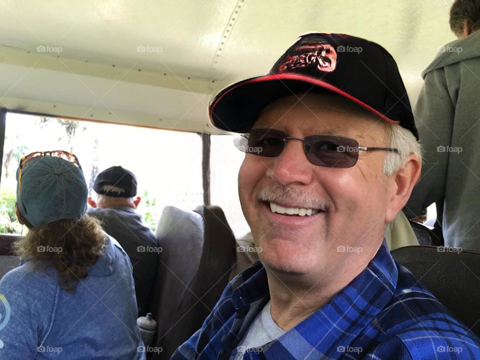 Smiling clean shaven man in sunglasses.