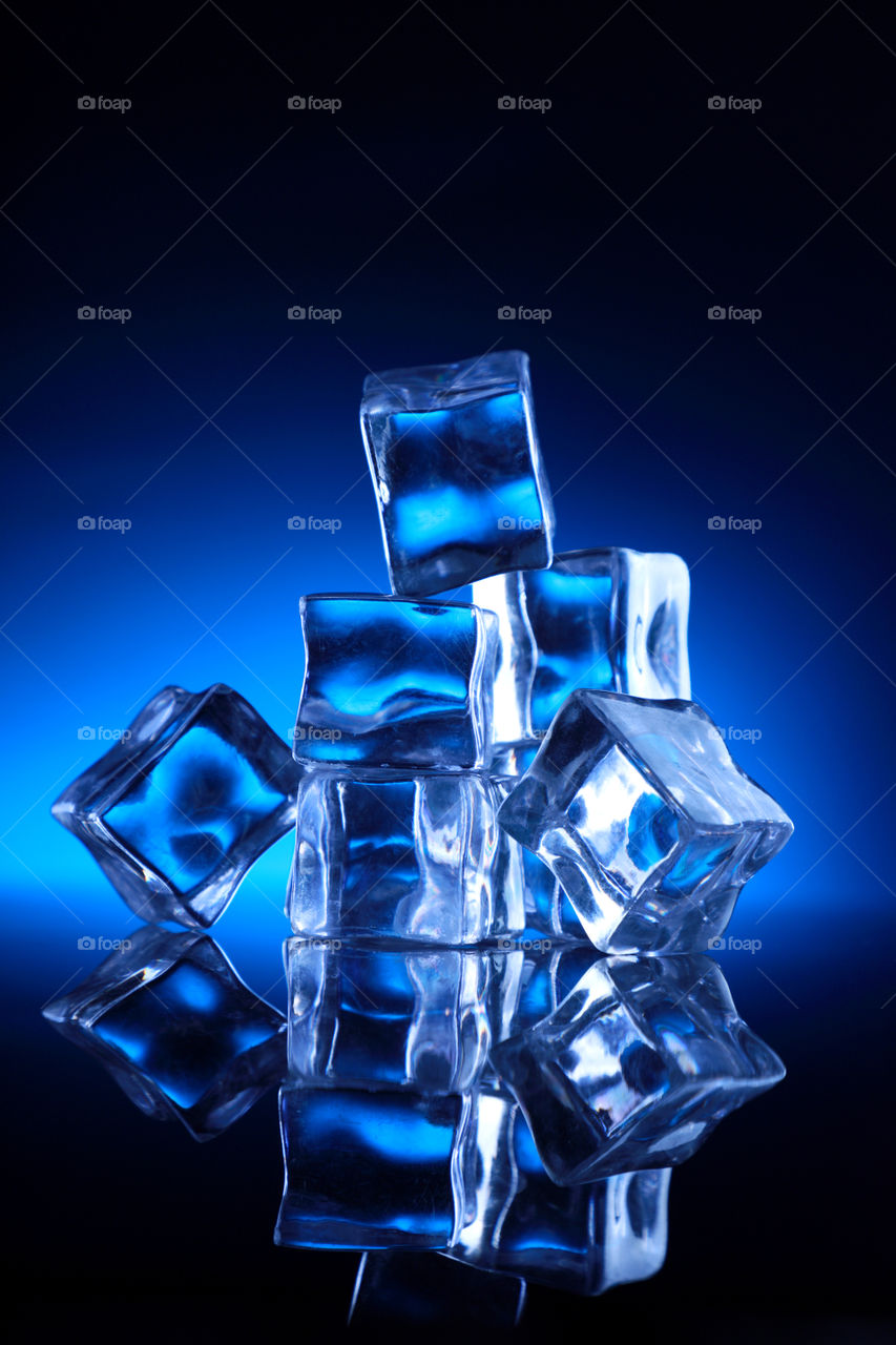 Frozen ice cubes on blue background