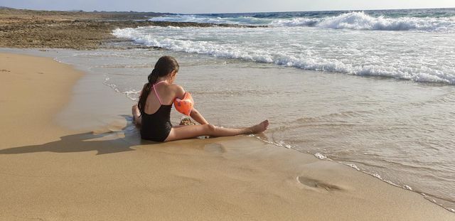 Girl playing with sand on the seashore
