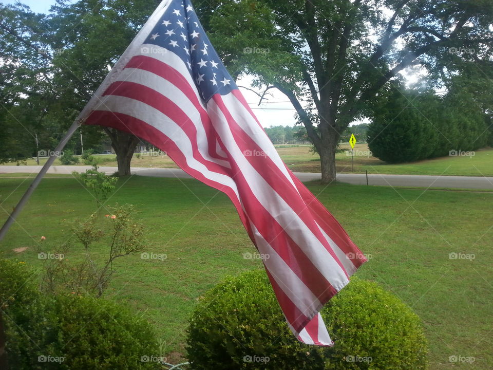 American flag flying proudly in the breeze from the porch.
