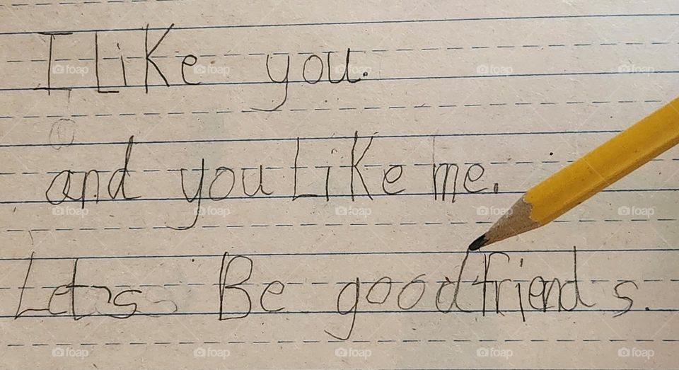 friendly message written in pencil by a child in school on lined paper to a classmate