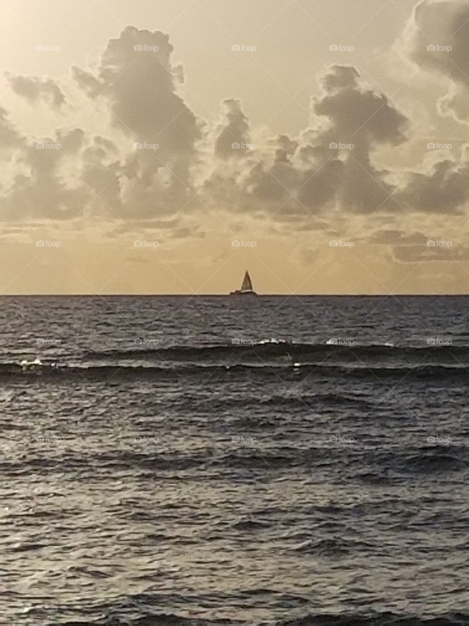 Sailboat on the ocean at sunset near Maui